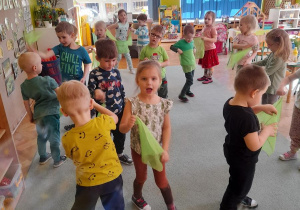 Dzieci tańczą z zielonymi chustkami
